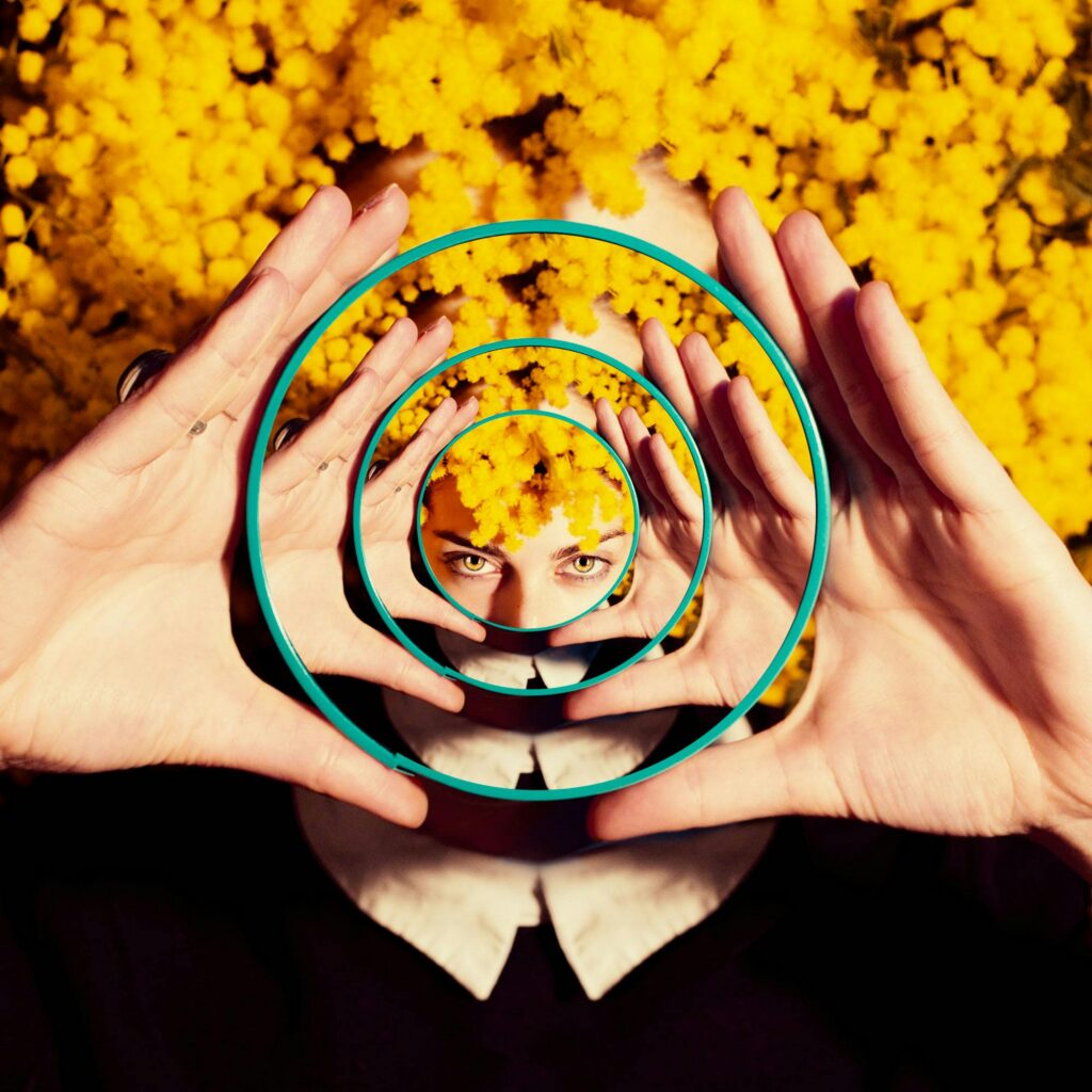 Creative conceptual portrait with mirrors and vibrant yellow flowers.