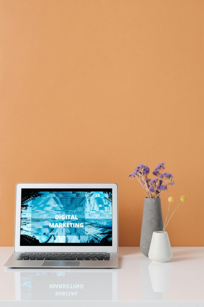 Modern workspace with laptop and decorative flowers showcasing digital marketing.